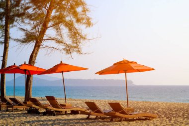 Plajda dinlenmek için şemsiyeli plaj sandalyeleri..