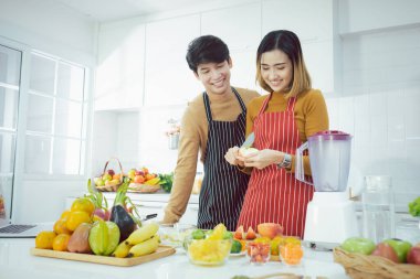 Genç çift evde mutfakta meyve püresi hazırlıyor, sağlıklı bir yaşam tarzı. Üst görünüm.