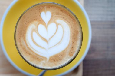 Ahşap masa arkasında Latte sıcak kahvenin (veya cappuccino) üst görüntüsü. Kapat..