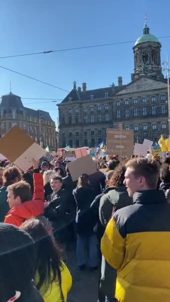 オランダ アムステルダム 2022 ウクライナの旗やプラカードを持つ人々は ウクライナでの戦争に対する抗議に参加します  — 無料ストック動画