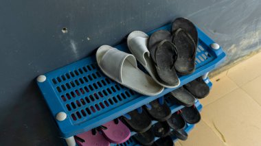 Evin önündeki ayakkabı ve sandaletler için plastik askılar. Mavi sandalet ya da ayakkabı dolabı