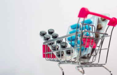 Tabakta mavi kapsüller, süpermarket sepetinde ilaçlar.