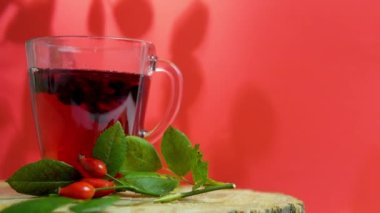  Kırmızı böğürtlenlerin kırmızı çayını ahşap, homeopatik bitki karışımında kırmızı arka planda iyileştirmek. Kırmızı gül suyu.