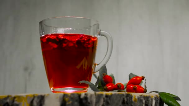 在杯子中放入香草和红莓的特写镜头 在木制背景上放上药用玫瑰臀部的茶 顺势疗法 — 图库视频影像