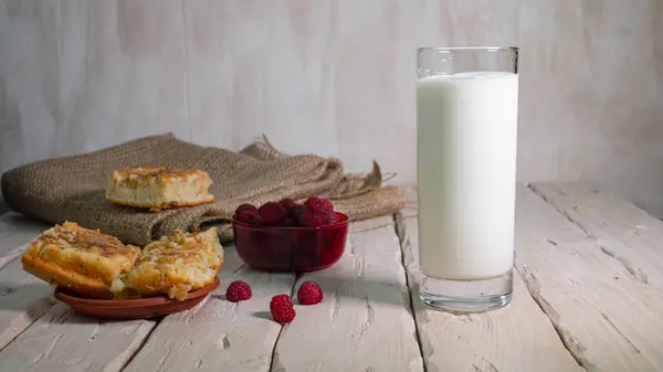 牛奶装在透明的玻璃杯里 有糕点和水果 新鲜的覆盆子放在木板上 水果酸奶 — 图库照片