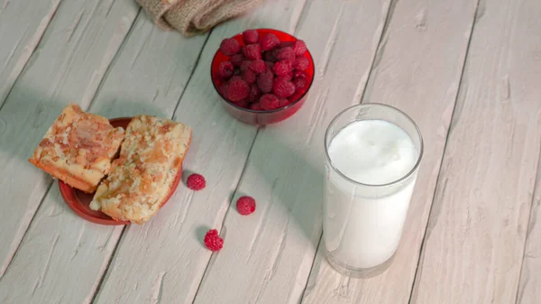 新鲜牛奶放在老式木板上的杯子里 盘中放覆盆子 水果酸奶 — 图库照片