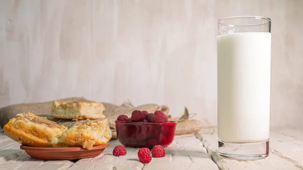 新鲜牛奶放在老式木板上的杯子里 牛奶和覆盆子还有酸奶一起过着平静的生活 — 图库照片