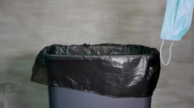 Kullanılmış tıbbi maskeyi çöp kutusuna at. Çöp kutusunda kirli maske
