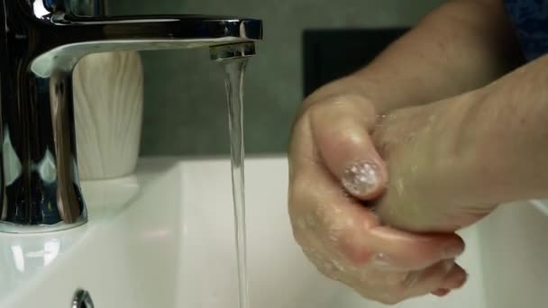 消毒用ハンドジェル コロナウイルスのパンデミックの予防は 暖かい水と石鹸で手を洗う 衛生コンセプトの手の詳細は スローモーション高齢者の女性は水でタップの下で彼女の手を洗う — ストック動画
