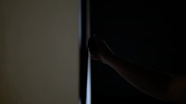 Bir adam karanlıkta eli ile kapıyı çalar, yaşlı bir kadın kapıyı çalar.