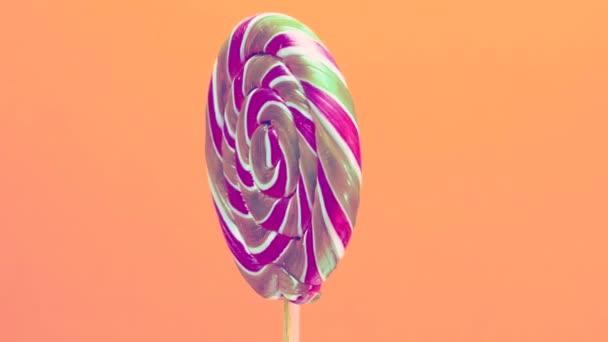 Close Spiral Lollipop Wooden Stick Orange Background Pastel Colors Sweet — Stock Video