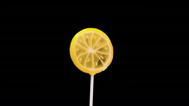 在黑色背景上的水果棒棒糖 焦糖柠檬糖在旋转 — 图库视频影像