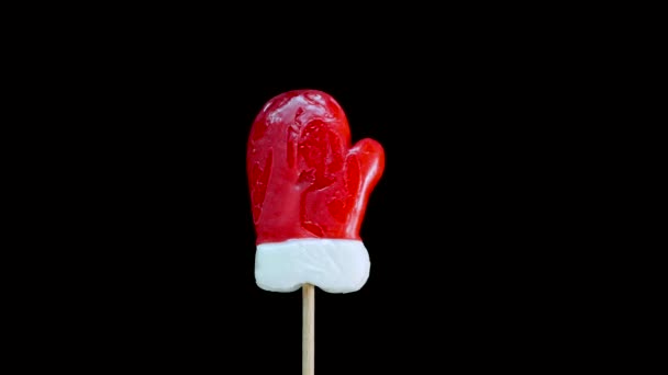Christmas Candy Spinning Santa Mitten Stick Black Background Caramel Candy — Stock Video