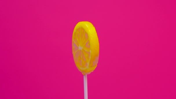 Lollipop Draait Een Stok Een Roze Achtergrond Citroen Snoep Een — Stockvideo