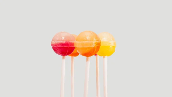 色彩斑斓的棒棒糖和糖果混合在一起 粘在一个浅灰色背景的复制空间上 — 图库照片