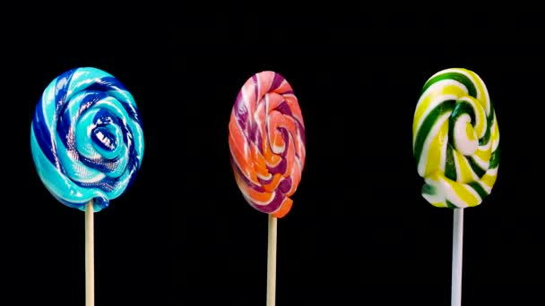 Tres Piruletas Diferentes Lollipop Verde Palo Girando Sobre Fondo Negro — Vídeos de Stock