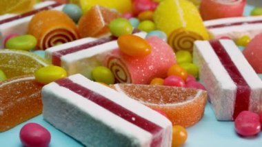 Yumuşak odaklanma. Portakal ve limonlu marmelat, vanilyalı pastil, karışık renkli tatlılar dönüyor. Çocuk tatlıları.