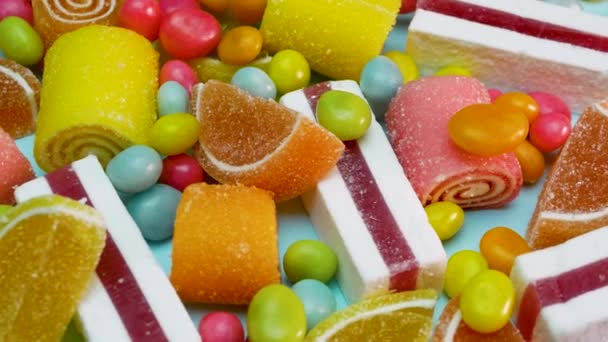 Meng Van Veelkleurige Gummisnoepjes Een Blauwe Achtergrond Snoepjesset Draait — Stockvideo