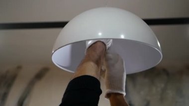Yanmış bir ampul, adamın biri avizenin vidalarını söker, dairedeki ampulü değiştirir..