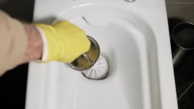 Tuvaleti fırçayla yıka. Ellerinde eldivenlerle banyoda klozet temizlerken.