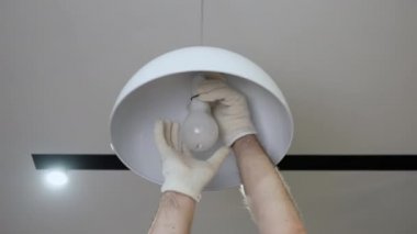 Elektrikçi dairedeki yanmış ampulü değiştirirken, usta ampulü modern bir avizeye vidaladı.