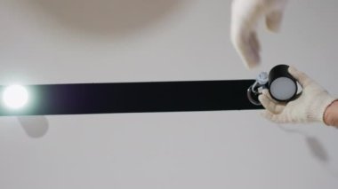 Modern bir ampulün bir usta tarafından değiştirilmesi. Dairelerde raylı aydınlatma, LED lamba yandı