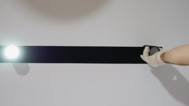 Elektrik işçisi bir dairede lamba tamir ediyor. Modern bir ampulün bir ustayla değiştirilmesi. Dairelerde raylı aydınlatma, LED lamba yandı