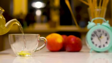 Mutfaktaki bir fincana bitki çayı dök. Homeopati konsepti. Çaydanlıktan saglik tentürü.
