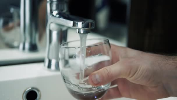 男性手持杯子倒入过滤过的饮用水 人消耗水 给杯子里灌满自来水 — 图库视频影像