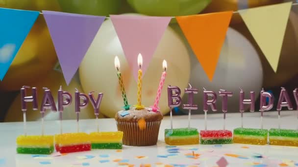 誕生日の背景 誕生日を祝うための美しいスクリーンセーバー ろうそくを灯したお祝いのカップケーキ — ストック動画