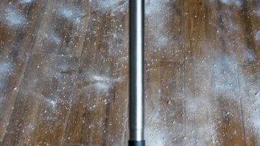 Çok kirli bir zemini kaldırıp, dağınık toz karışımını süpür. Adam yerdeki fayansları süpürüyor..