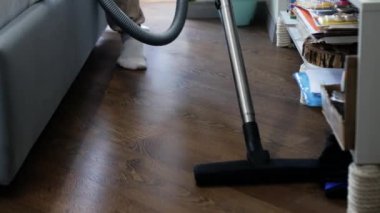 Adamın biri dairenin parke zeminini süpürdü.