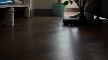 Adamın biri dairedeki kaplamaları süpürüyor.