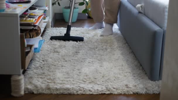 男がアパートのフリースの絨毯を掃除している 部屋の掃除 カーペットを掃除して掃除機で掃除する — ストック動画