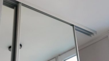 Dairelerdeki aynalı kapılar. Gardıroptaki sürgülü kapılar, kompartımanın sürgülü kapılarını açma ve kapatma sistemi. Giysiler için depolama alanı