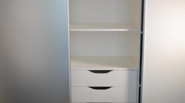 Gardıroptaki sürgülü kapılar, kompartımanın sürgülü kapılarını açma ve kapatma sistemi. Giysiler için depo alanı. Alüminyum raylı çağdaş gardırop. Mobilyalar iç tarafta.