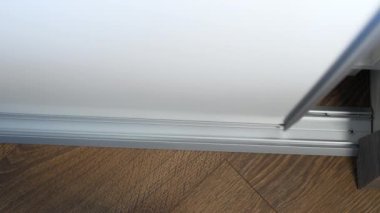 Tekerlekleri yakın çekimli alüminyum korkuluklara bir kapı monte edildi. Dolap sürgülü kapı sistemi, sürgülü kompartıman sürgülü kapı açma ve kapama sistemi