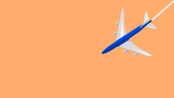 在飞行中的客机在橙色背景下被隔离 蓝色飞机在空中被跟踪 复制太空飞机模型 — 图库照片