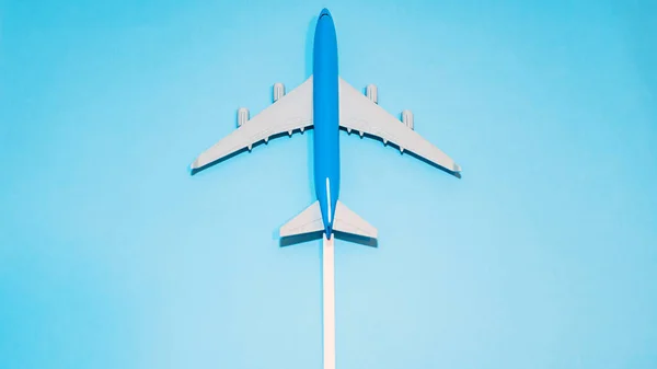 蓝色客机顶部的视图 带有小径白迹的飞行中飞机的仿制空间模型 — 图库照片