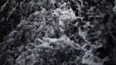 Siyah beyaz gölgelerde güçlü bir su akıntısı, şelaleye güçlü bir su akıntısı. Dağ suyu akıntısının arka planı.