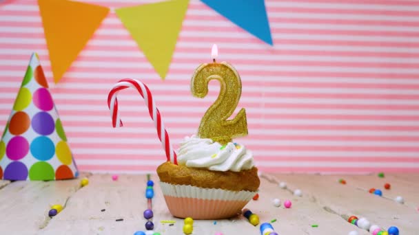 给两岁小孩的生日快乐 给两岁小孩的生日快乐 一个漂亮的视频背景 一个粉红的背景 一个奶油蛋糕 一支点燃的蜡烛 — 图库视频影像