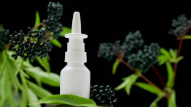 Siyah arka planda kara dutlu burun spreyi, homeopatik tedavi, yaşlı böğürtlenlerine dayalı tıbbi burun spreyi.