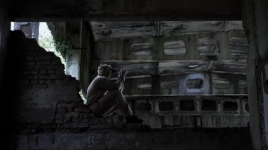 İnsanlardaki sosyal sorunlar. Terk edilmiş bir binada üzgün bir adam, depresif bir adam. Sinema tonu. Genç bir adamın hayatındaki sorunlar