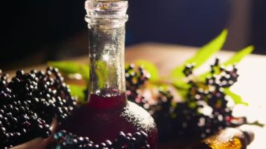 Tahtada böğürtlen, böğürtlen suyu ile ilaç şişesi. Homeopati. Kırmızı bitkisel tentür.