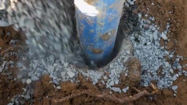 Su borusu. İşçi kuyuya moloz döker ve elektrik kaynağı yerleştirir.