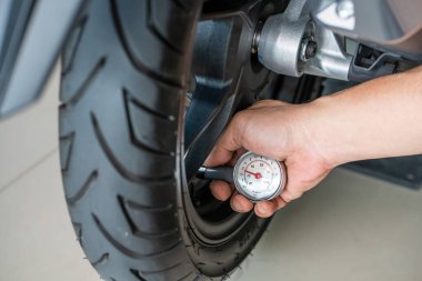 Taşınabilir lastik basıncı göstergesi. Motosiklet lastiği için hava basıncını kontrol ediyor. Garajda tamirat, motor konsepti. Seçici odaklanma
