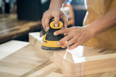 Marangoz atölyedeki ahşap, DIY üreticisi ve ahşap işçiliği gibi rastgele yörünge zımpara makinesi ya da el değirmeni kullanır. seçici odak