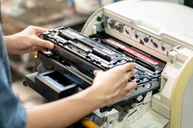 Lazer toner kartuşu tutan kadınlar, ofiste lazer yazıcının tonerini değiştiren kadınlar. Onarımlar ve Bakım Lazer yazıcıları kavramı        