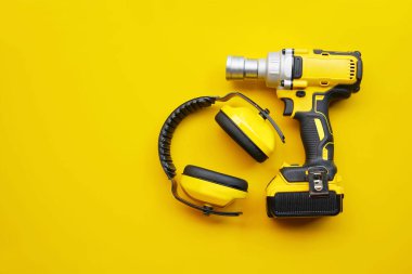 elektrikli aletler, kulaklık, orta menzilli kablosuz etki anahtarı sarı arkaplan üzerinde Safety ekipman kavramı .                         