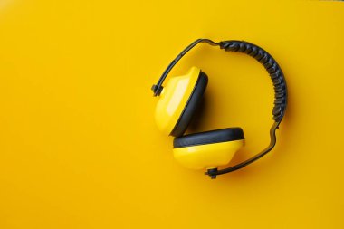 Önce sarı arka planda koruyucu kulaklık. Güvenlik kavramları.